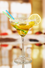 Yellow cocktail in glass on room background