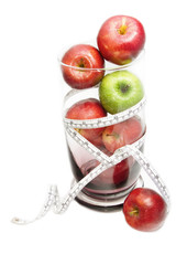 Green apple on red apple in glass jar