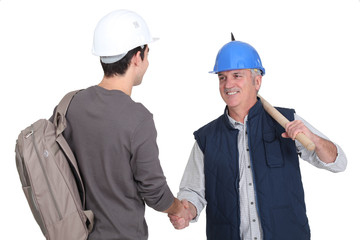 Builder welcoming teenage helper