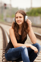 Fototapeta premium Teen girl with headphones at railways.