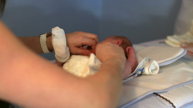 Mother Dressing Her  Baby