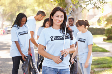Team Of Volunteers Picking Up Litter In Suburban Street