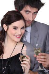 Young man and woman smiling holding champagne glasses