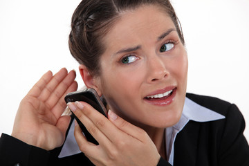 young businesswoman straining her ears with cell phone