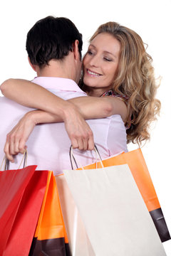 Woman with bags hugging boyfriend