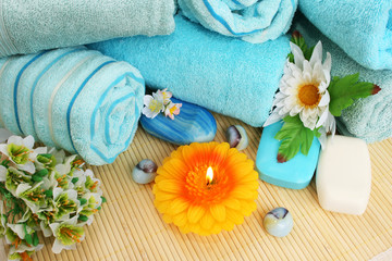 Obraz na płótnie Canvas Ręczniki, mydła, kwiaty, świece