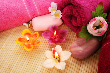 Obraz na płótnie Canvas Ręczniki, mydła, kwiaty, świece