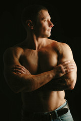 Healthy muscular young man. Isolated on black background