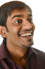 Smiling young Indian man, looking off camera - isolated on white
