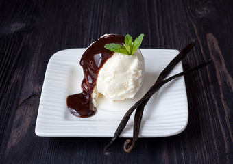 Vanilla ice cream with chocolate syrup and vanilla sticks