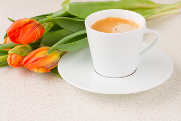 cup of coffee with orange tulips