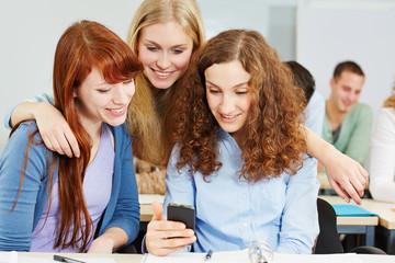 Frauen schauen auf Smartphone in der Uni