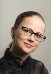 Portrait of the serious young woman in glasses