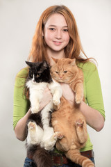 The red-haired girl holds two cats