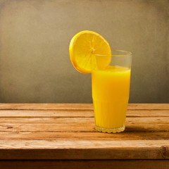 Glass of fresh orange juice on wooden vintage table