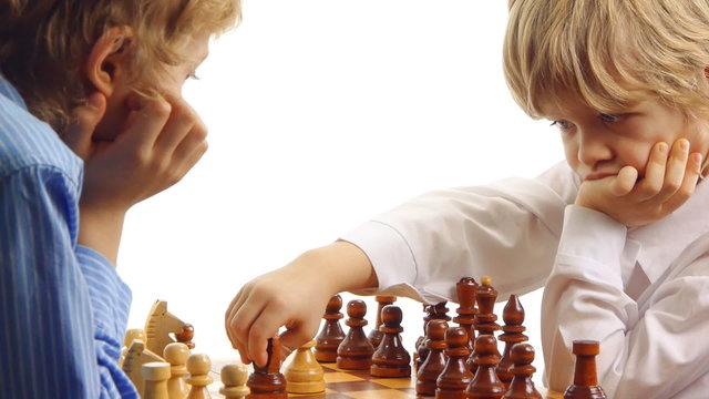 Two boys thinking and playing chess