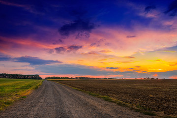 Fototapeta na wymiar Droga w łąki i zachód słońca piękne
