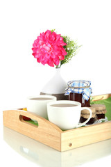 Cups of tea with flower and jam on wooden tray isolated on