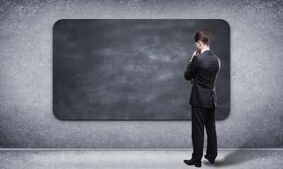 man looking at blackboard