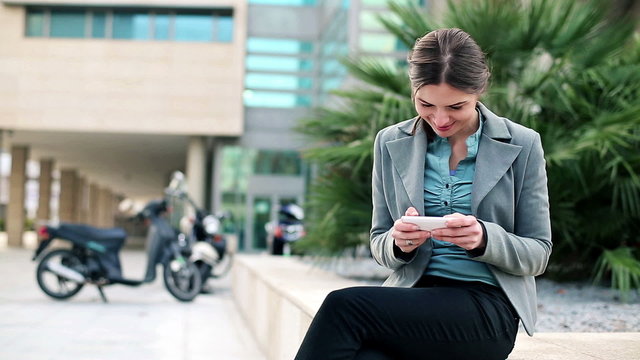 Young businesswoman using smartphone in the city