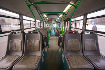 Fototapeta na wymiar Wnętrze nowoczesnego autobusu miejskiego na przystanku. Strzał z tyłu