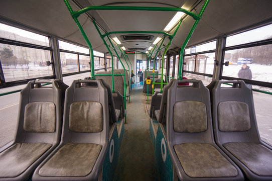 Interior of modern city bus on bus stop. Shot from back side of