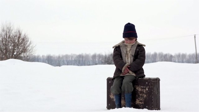 boy with a suitcase in winter