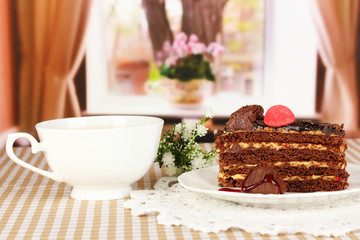 Cup of tea and delicious cake on window background