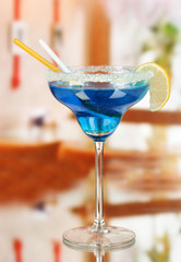 Blue cocktail in glass on room background
