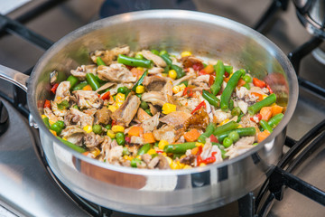 Chicken fried with vegetables on a sauce pan