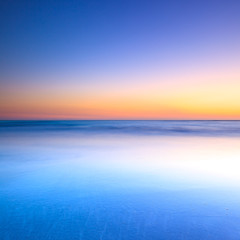 Naklejka na ściany i meble Biała plaża i niebieski ocean na zachód słońca w półmroku