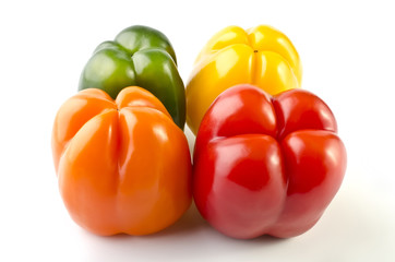 Four colorful peppers isolated over white