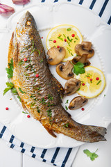 Roasted fish with lemon, mushrooms and herbs