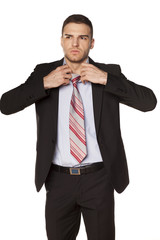 attractive businessman unfasten the tie on white background