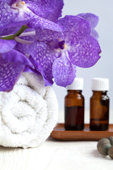 Spa still life with blue orchid flower, towel and aromatic oils