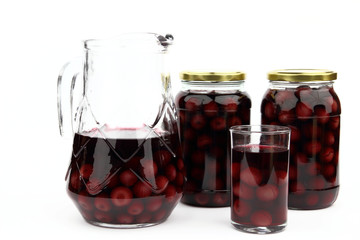 Compote with cherries in jars, glass and ewer