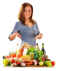 Young woman with variety of grocery products isolated on white