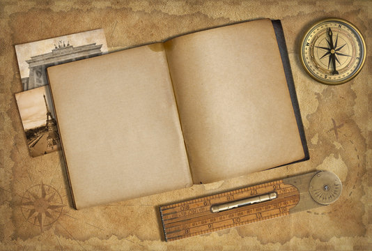 Open diary over old treasure map with compass
