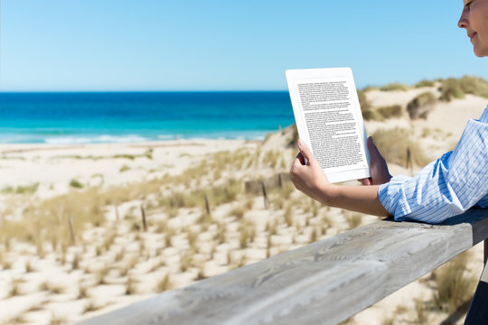 frau liest ein ebook am strand
