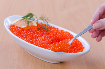 Women hand shows quality of red caviar