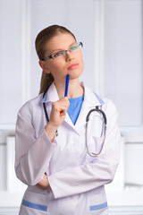 Portrait of Thinking Woman Doctor Wearing Stethoscope