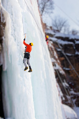 Man climbing frozen waterfall