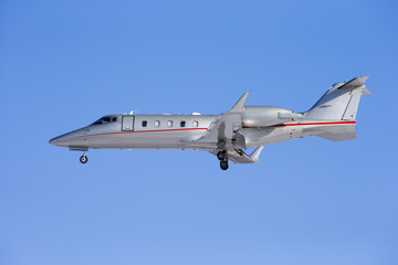 Business jet taking off isolated on a blue sky background.