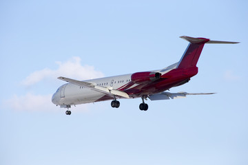 Passenger plane sits isolated on a blue sky background.