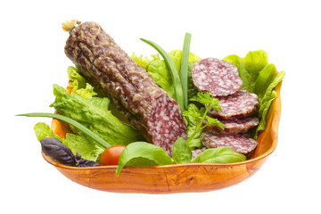 Ripe salami with salad, basil, onion and tomato