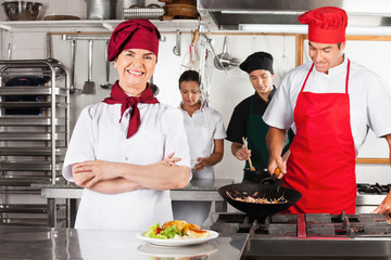 Female Chef With Arms Crossed In Kitchen