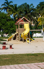 Fototapeta na wymiar Yellow Slides in Tropical Playground