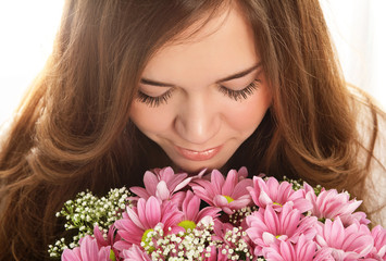 Fototapeta premium portrait of a beautiful girl with luxurious long hair and a pink