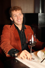 Happy young man in red suit in a restaurant