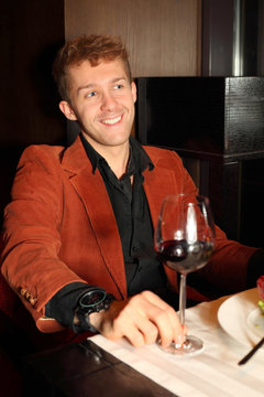 Happy Young Man In Red Suit In A Restaurant